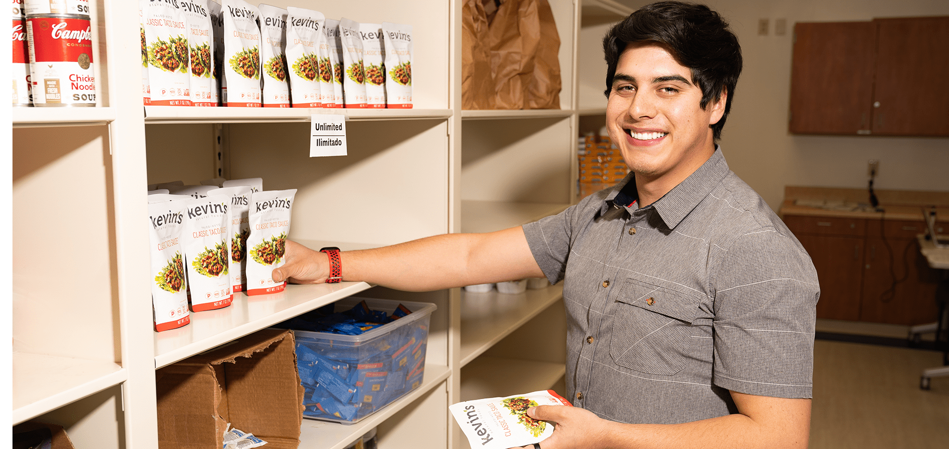 student worker at food pantry restocking shelves