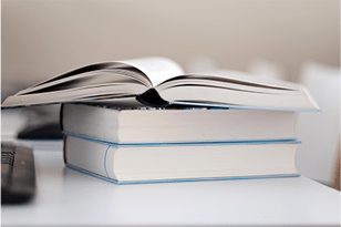 open textbook on top of stack of closed books