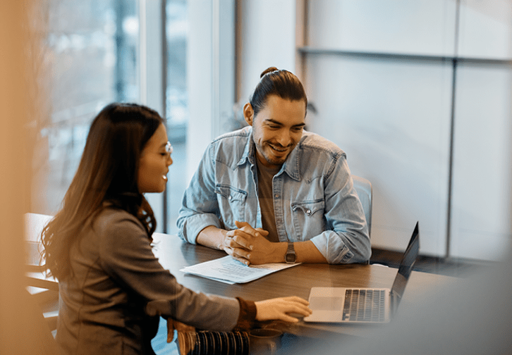 two people in a meeting looking at a laptop