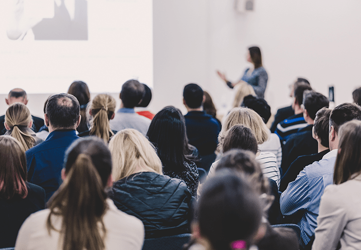 a presentation in a room with a crowd of people