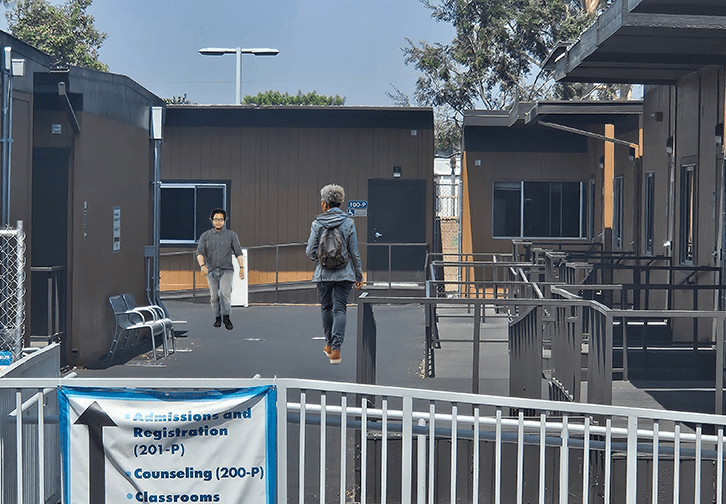 people walking near the east lot portables