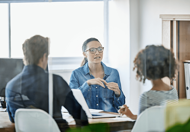 three people in an office having a meeting