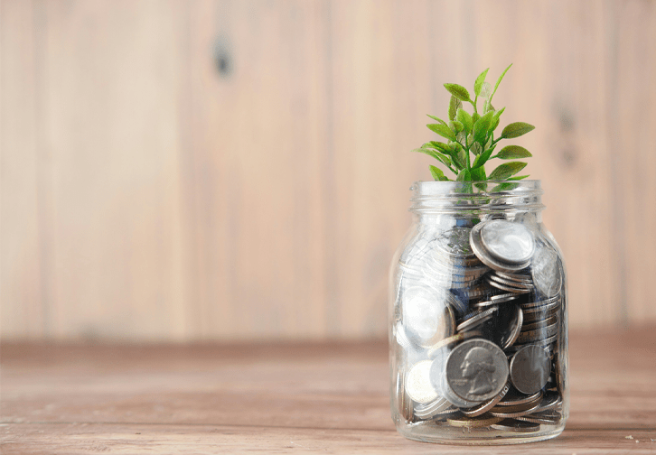 jar of quarters with a plant coming out at the top