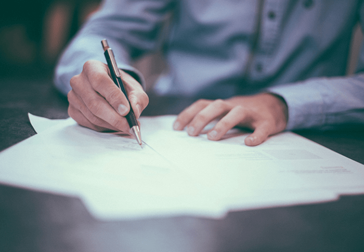 person writing on a piece of paper