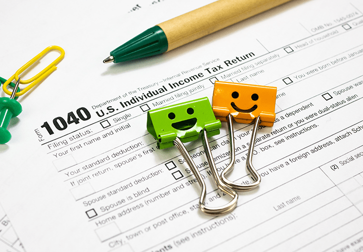 paper clips with happy faces sitting on tax form