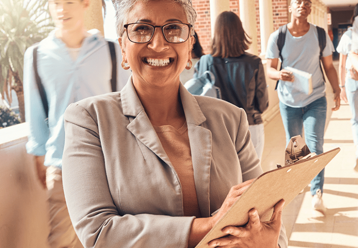 woman holding clipboard with students walking around her