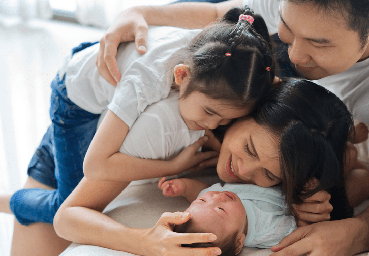 a family cuddling a newborn