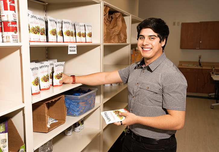 student worker at food pantry restocking shelves