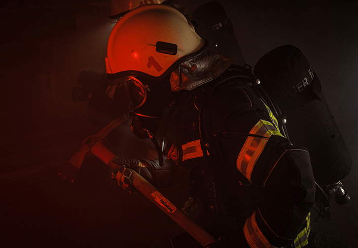 firefighter in a dark building holding an ax