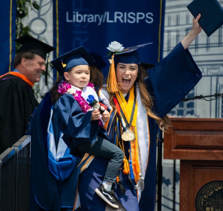 Graduating student holder her child as she received degree at commencement 