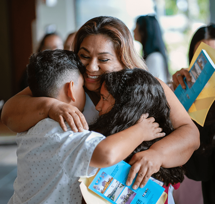 Mother hugging her children at NOCE student success event