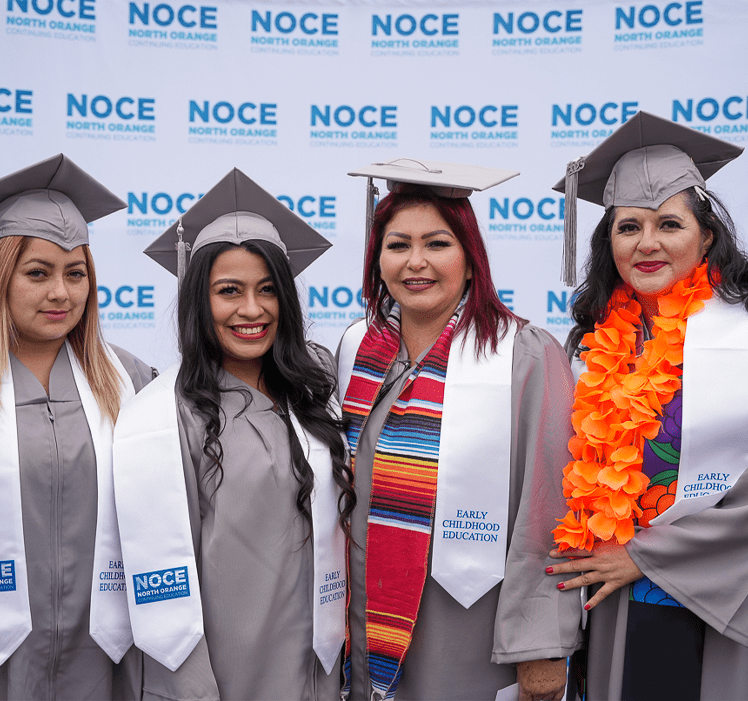 four graduates from noce in graduation regalia