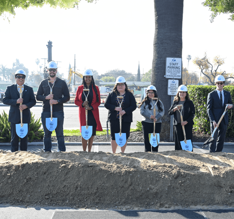 Fullerton College officials in hard hats carrying shovels for groundbreaking ceremony