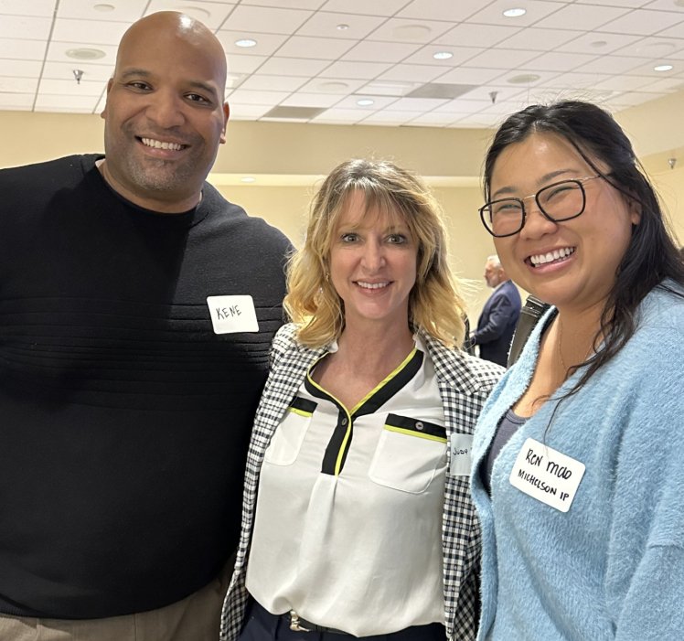 three people standing together smiling