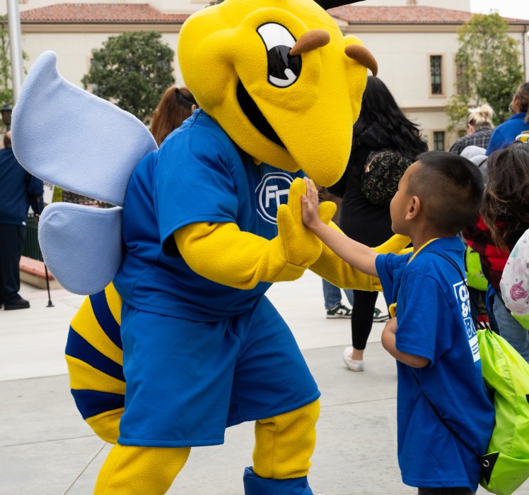 child high-fiving hornet mascot