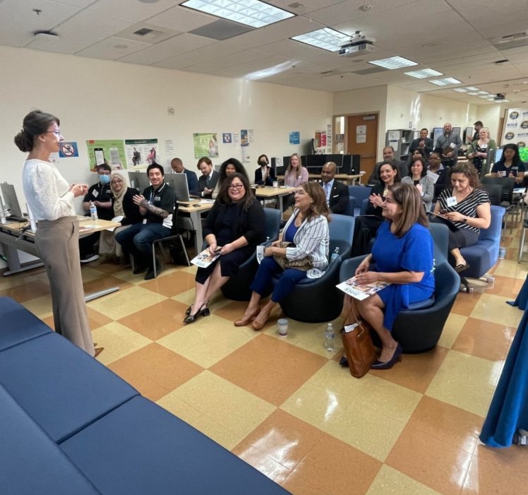 woman speaking in front of seated adults 