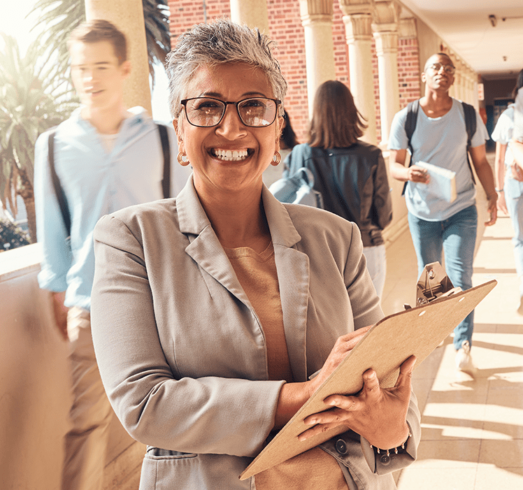 woman holding clipboard with students walking around her