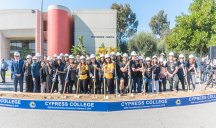 large group at groundbreaking ceremony with hard hats and shovels