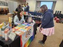 employee getting information from the LGBTQ Center information table