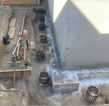 View looking down at pillars under construction around the base of a building